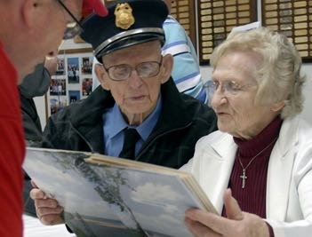 Bob Theadore looks on as veteran firefighter Earle Poley and his wife Mae examine memorabilia from the NBVFD during the 100th anniversary of the local department. In 2010, Poley was the oldest member of the department at the age of 90.